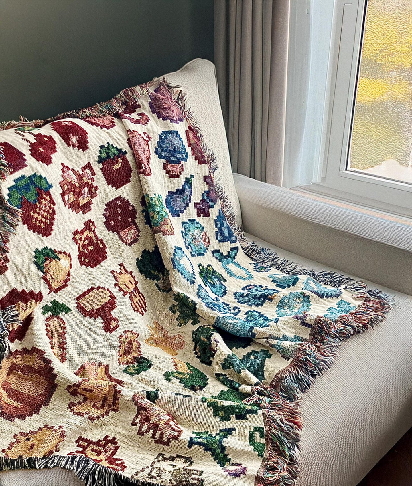 Decorative blanket with colorful patterns draped over a couch by a window.